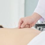 144212876-primer-plano-de-las-manos-haciendo-acupuntura-con-la-espalda-del-paciente-concepto-de-medicina