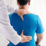 Doctor physiotherapist doing healing treatment on man's back.Back pain patient, treatment, medical doctor, massage therapist.office syndrome